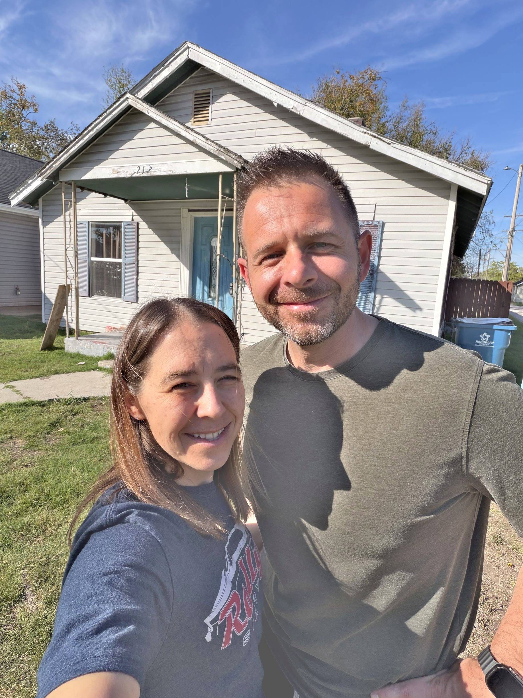 Cody and Keri smiling together in front of a house